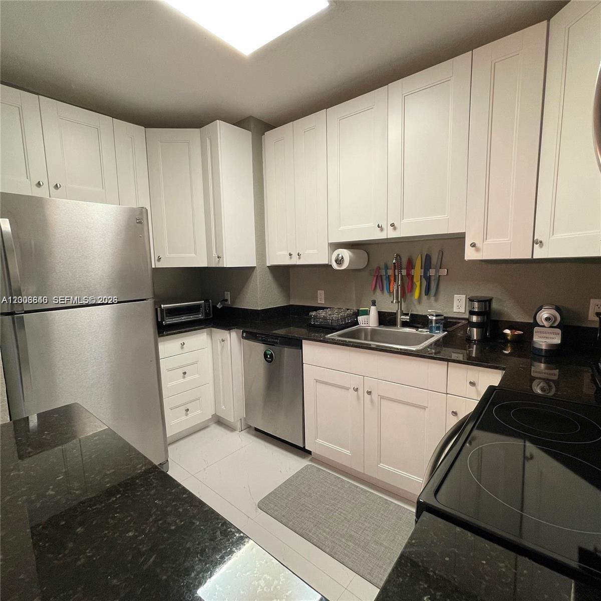 1380 Southwest 11th Street, Unit 1 Miami, FL 33135 - Photo 5 of 20 a kitchen with granite countertop white cabinets and refrigerator