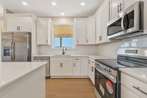 a kitchen with stainless steel appliances granite countertop a sink and a stove