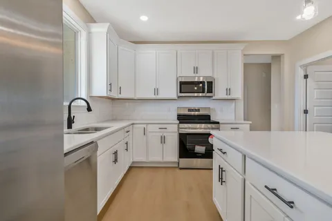 a kitchen with stainless steel appliances granite countertop a sink stove and refrigerator