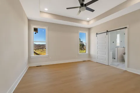 an empty room with a ceiling fan and a window