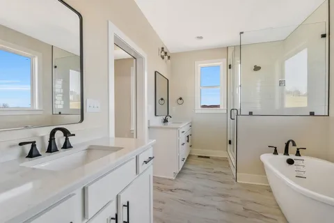 a bathroom with a sink a large mirror and shower