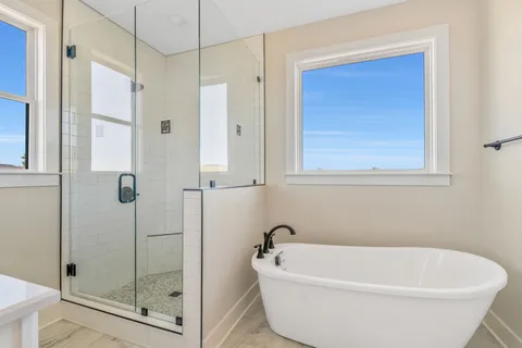 a white bath tub sitting next to a shower