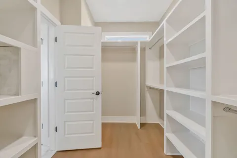 a view of walk in closet with empty racks
