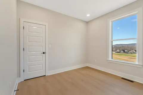 an empty room with a window and wooden floor