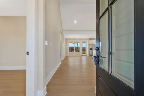 a view of a hallway with a livingroom and furniture