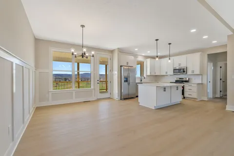 a large kitchen with stainless steel appliances kitchen island granite countertop a refrigerator a stove a sink dishwasher with a dining table and chairs