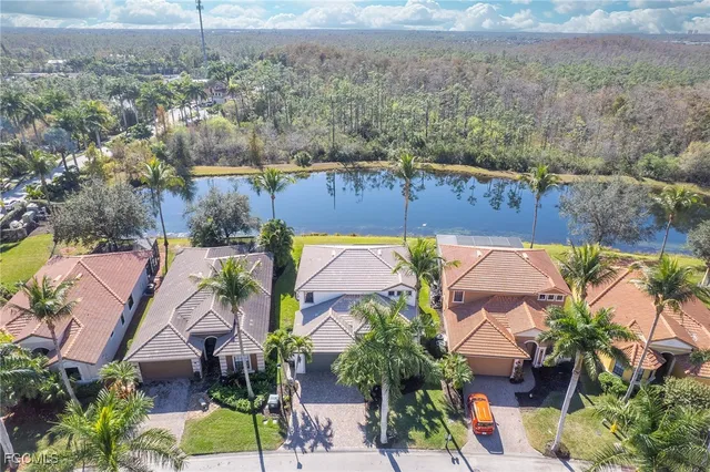 an aerial view of a house with a yard and lake view