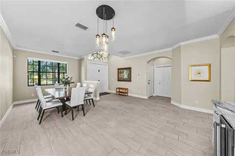 a view of a dining room with furniture a chandelier and wooden floor