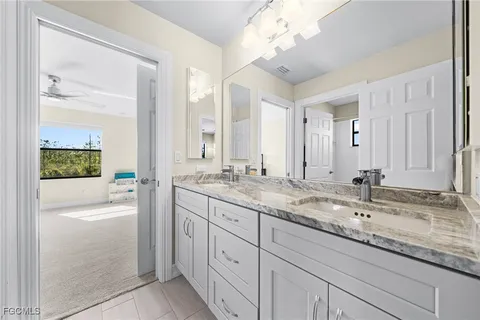 a bathroom with a granite countertop sink and a mirror