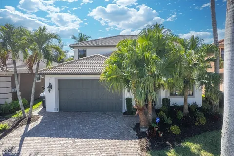 a view of a house with a yard and palm trees