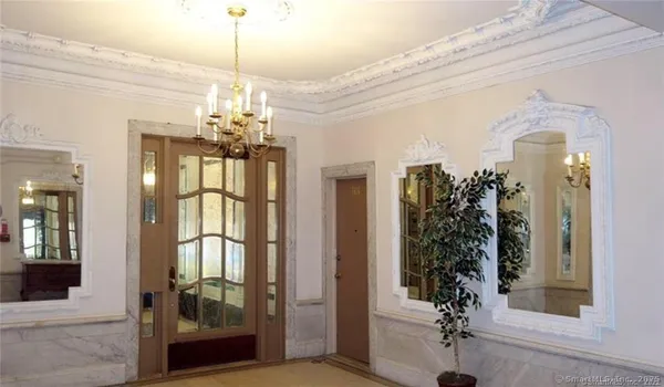 a view of a room with a chandelier and wooden floor