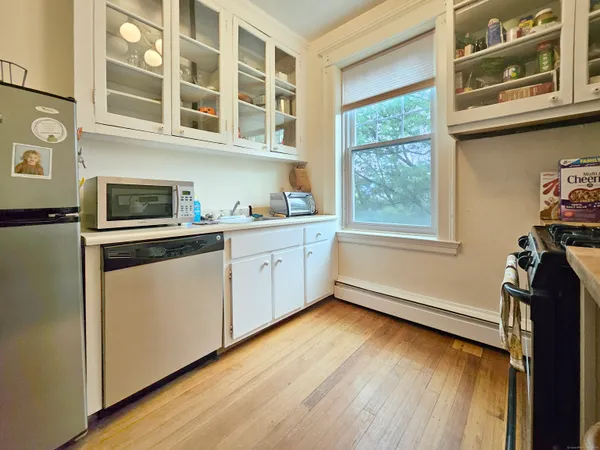 a kitchen with a stove window and wooden floor
