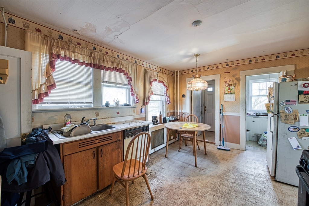 3 Crescent Road Needham, MA 02494 - Photo 10 of 15 a kitchen with a table chairs stove and refrigerator