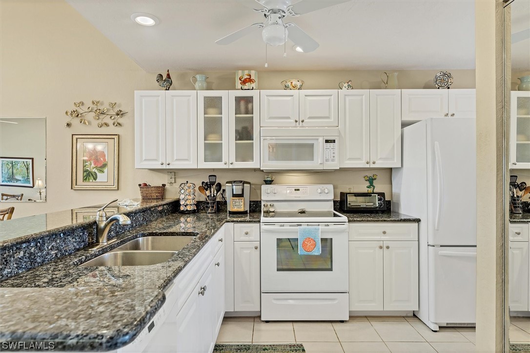 6800 Placida Road, Unit 2002 Englewood, FL 34224 - Photo 12 of 25 a kitchen that has a lot of white cabinets and stainless steel appliances
