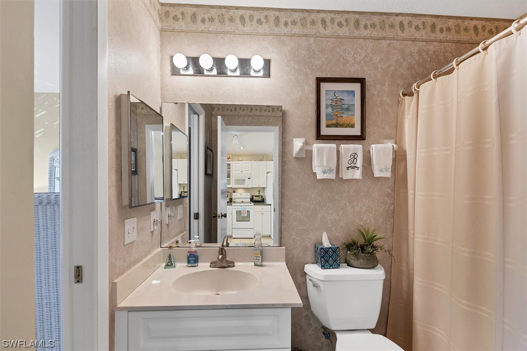 6800 Placida Road, Unit 2002 Englewood, FL 34224 - Photo 16 of 25 a bathroom with a sink mirror vanity and toilet