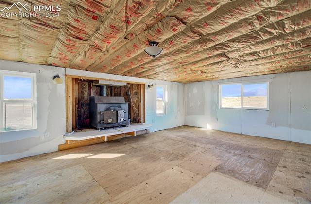 9765 Berridge Road Calhan, CO 80808 - Photo 17 of 27 Unfurnished living room with a wood stove