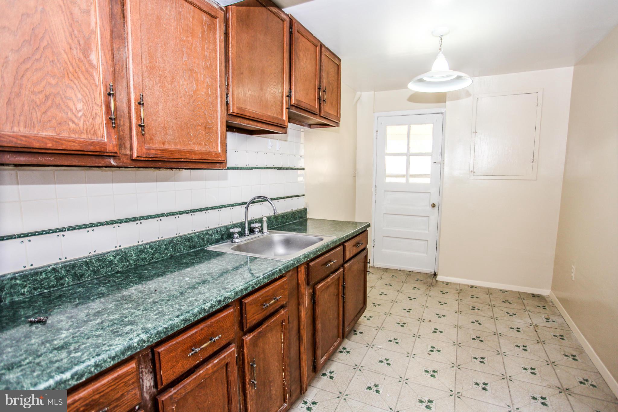 7620 Dunston Street Springfield, VA 22151 - Photo 19 of 24 a kitchen with a sink a stove cabinets and a wooden floor