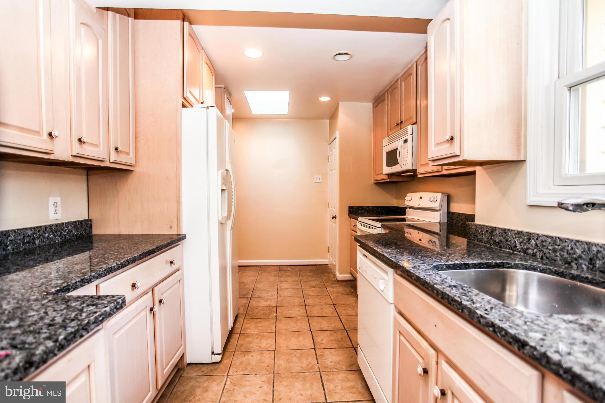 7620 Dunston Street Springfield, VA 22151 - Photo 5 of 24 a kitchen with granite countertop a sink stove and cabinets