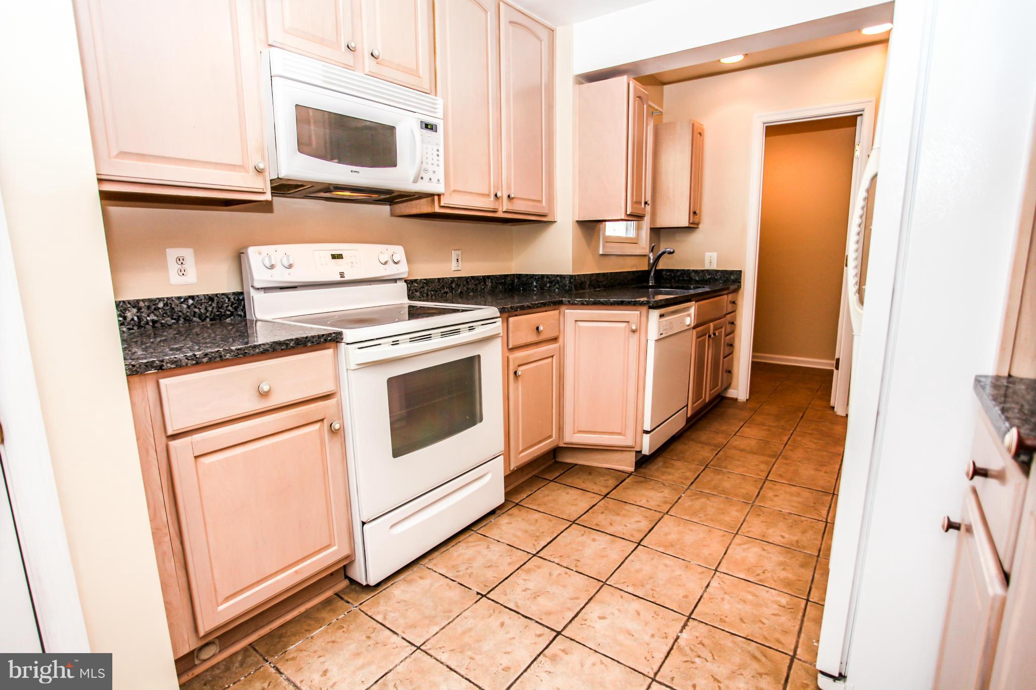7620 Dunston Street Springfield, VA 22151 - Photo 6 of 24 a kitchen with stainless steel appliances granite countertop a stove a sink and a microwave