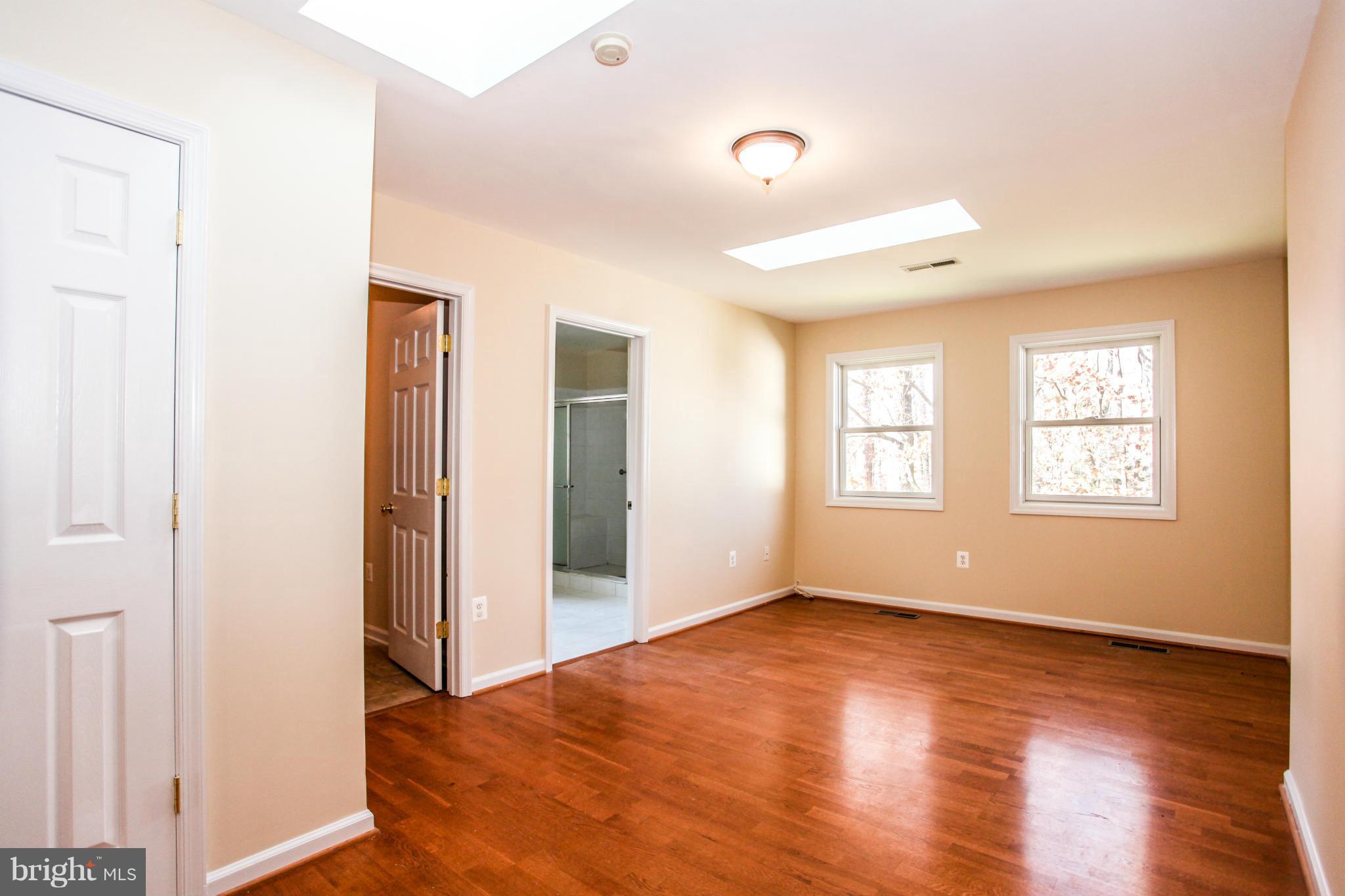7620 Dunston Street Springfield, VA 22151 - Photo 7 of 24 a view of empty room with wooden floor and fan