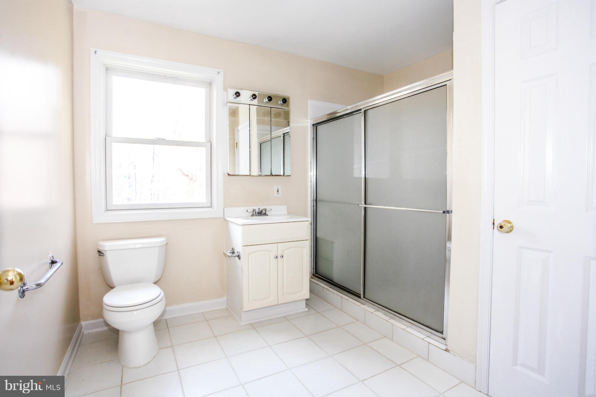 7620 Dunston Street Springfield, VA 22151 - Photo 9 of 24 a bathroom with a toilet sink and a shower