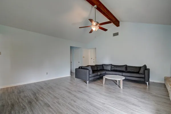 a living room with furniture and a wooden floor