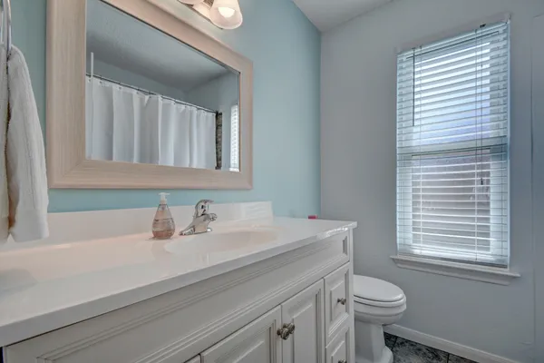 a bathroom with a sink a toilet and a mirror