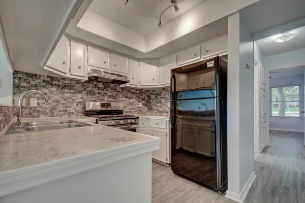 a kitchen with a refrigerator and a stove top oven