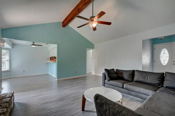a living room with furniture and a wooden floor
