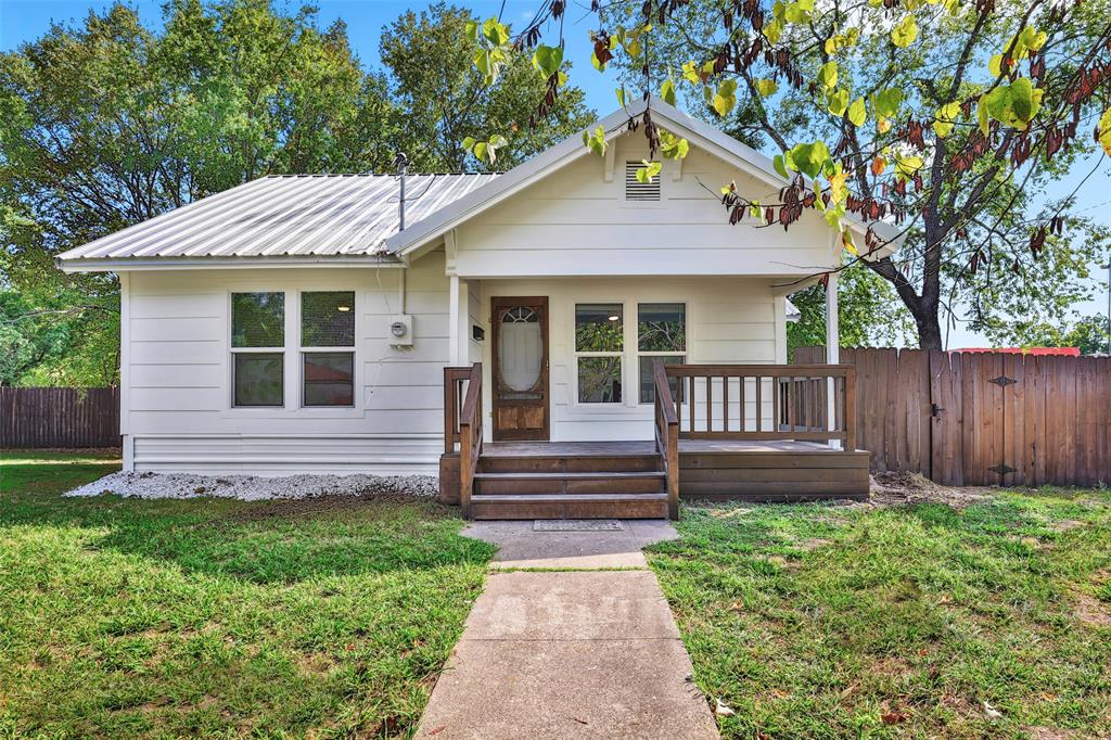 1005 North Neal Street Commerce, TX 75428 - Photo 1 of 23 a front view of a house with a garden