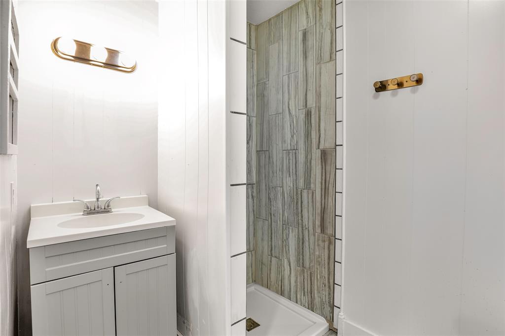 1005 North Neal Street Commerce, TX 75428 - Photo 16 of 23 a bathroom with a sink and a mirror