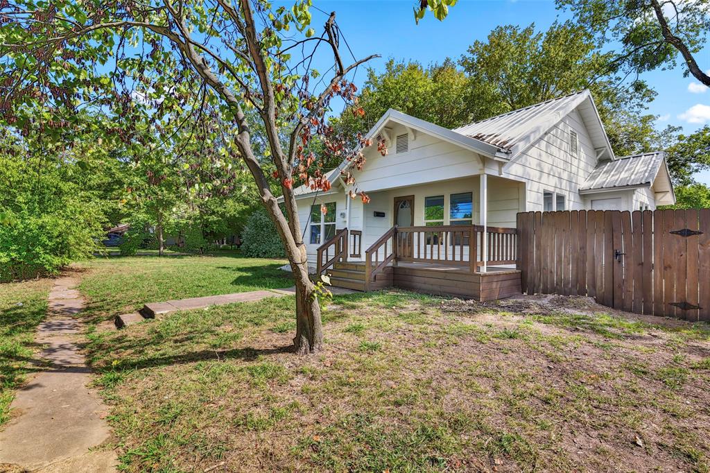 1005 North Neal Street Commerce, TX 75428 - Photo 3 of 23 a view of a house with a yard and a large tree