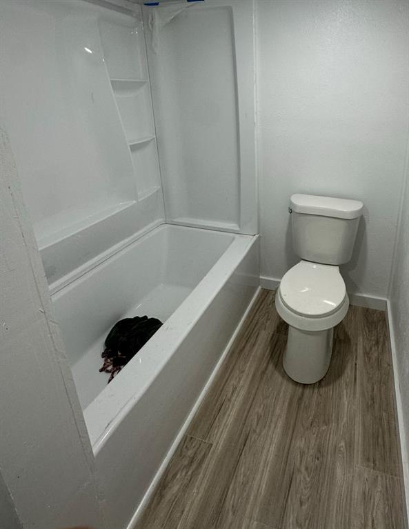 1005 North Neal Street Commerce, TX 75428 - Photo 8 of 23 a bathroom with a toilet and a tub