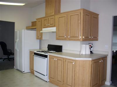 Modern kitchen with side by side refrigerator, gas stove and lots of cabinets for storage.