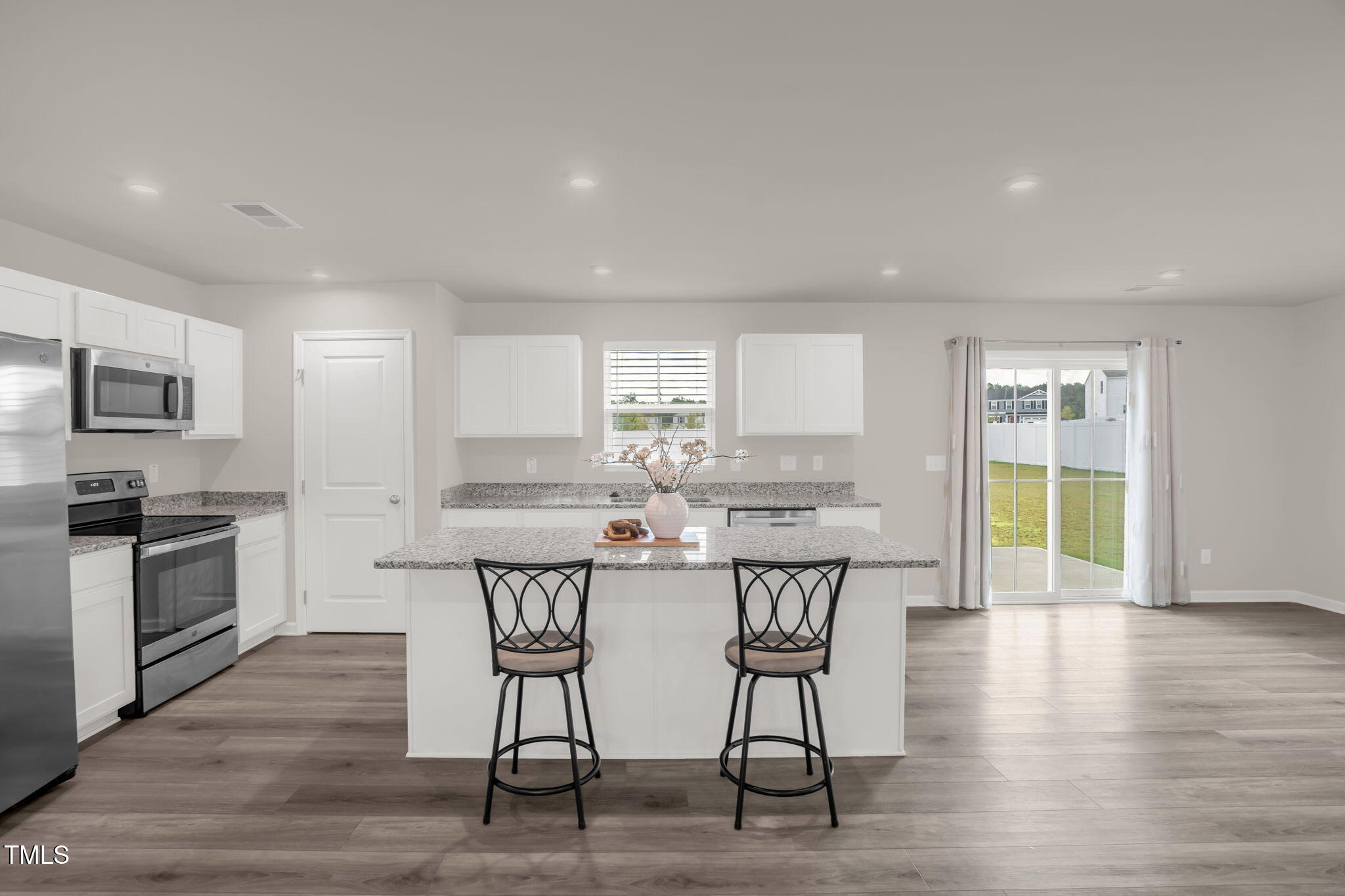 801 Brook Bawn Road Wendell, NC 27591 - Photo 10 of 30 a kitchen with stainless steel appliances a dining table chairs and wooden floor