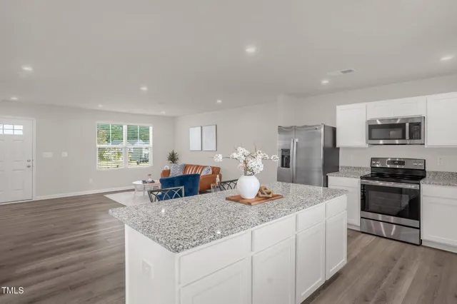 a kitchen with granite countertop kitchen island cabinets and appliances