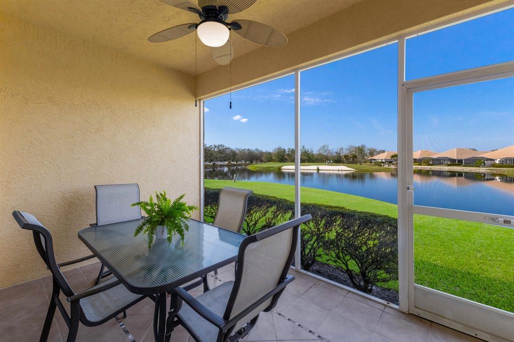 8414 Wethersfield Run, Unit 102 Lakewood Ranch, FL 34202 - Photo 26 of 48 a view of a chairs and table in patio with a yard