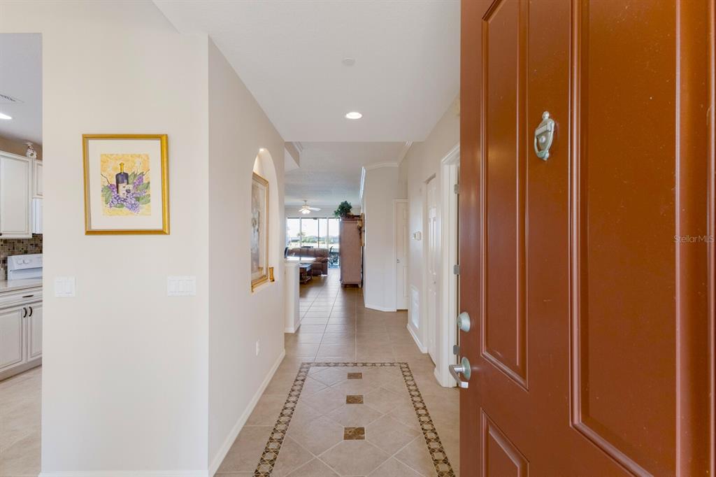 8414 Wethersfield Run, Unit 102 Lakewood Ranch, FL 34202 - Photo 4 of 48 a view of a hallway with wooden floor and a bathroom