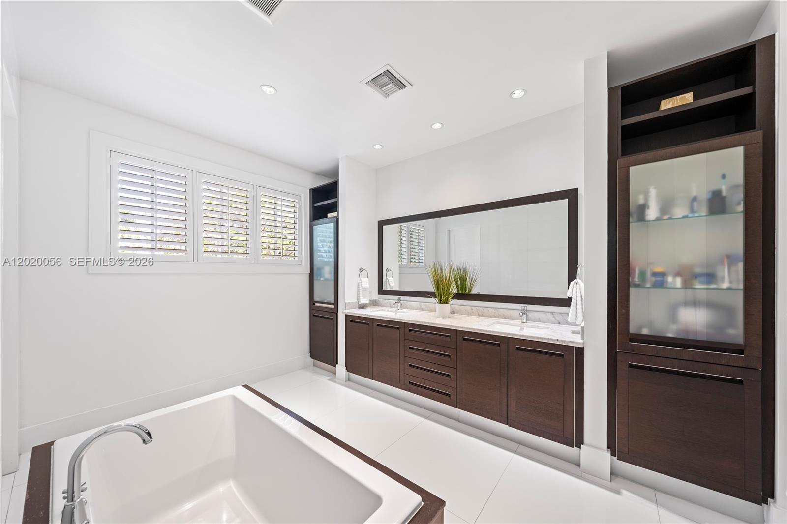 4196 Douglas Road Miami, FL 33133 - Photo 54 of 96 a bathroom with a sink and a large mirror