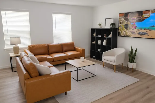 a living room with furniture and a wooden floor