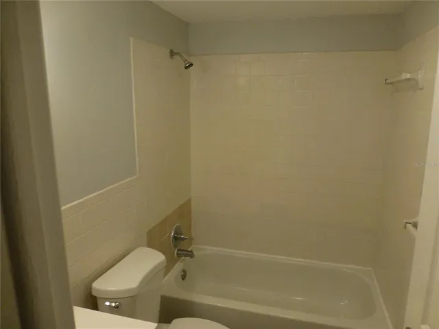 a white toilet sitting next to a bath tub