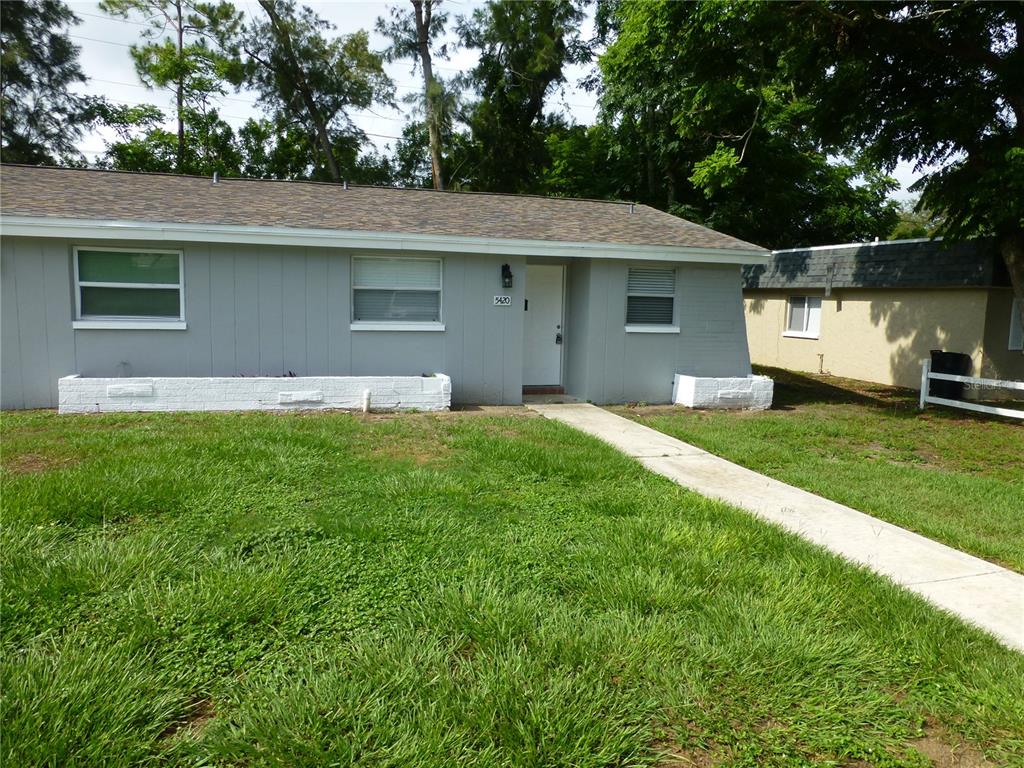 5420 Reef Drive New Port Richey, FL 34652 - Photo 2 of 14 a front view of a house with a yard and garage