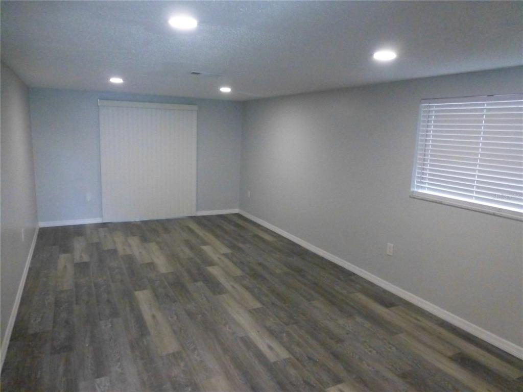 5420 Reef Drive New Port Richey, FL 34652 - Photo 4 of 14 an empty room with wooden floor and windows