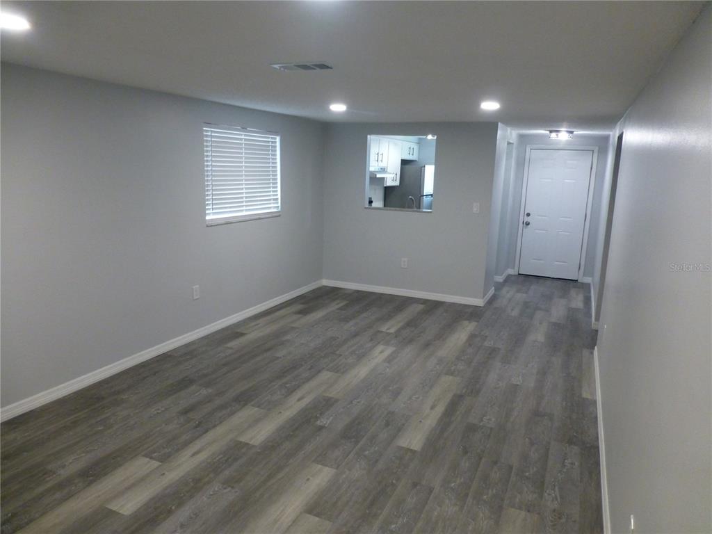 5420 Reef Drive New Port Richey, FL 34652 - Photo 8 of 14 an empty room with wooden floor and windows
