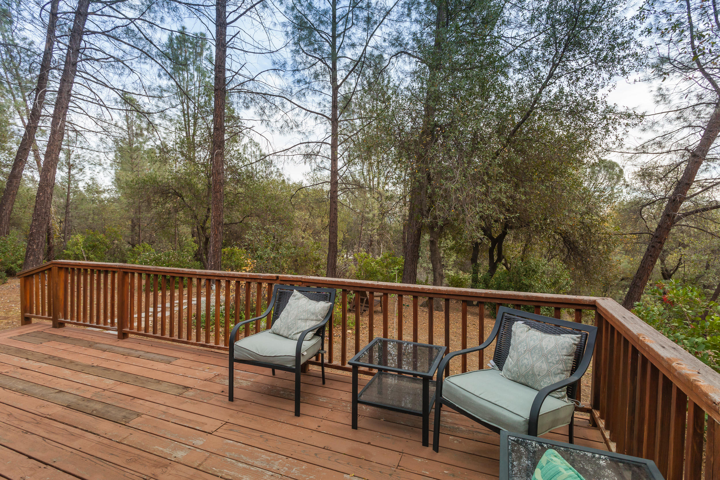 12199 Macs Road Redding, CA 96003 - Photo 18 of 36 a view of a wooden deck with furniture