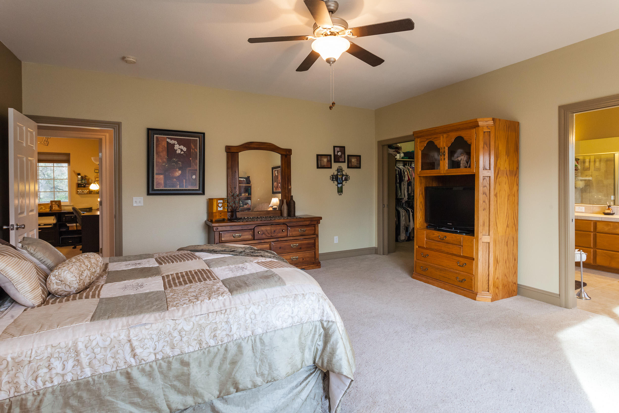 12199 Macs Road Redding, CA 96003 - Photo 28 of 36 a bedroom with a bed and a chandelier