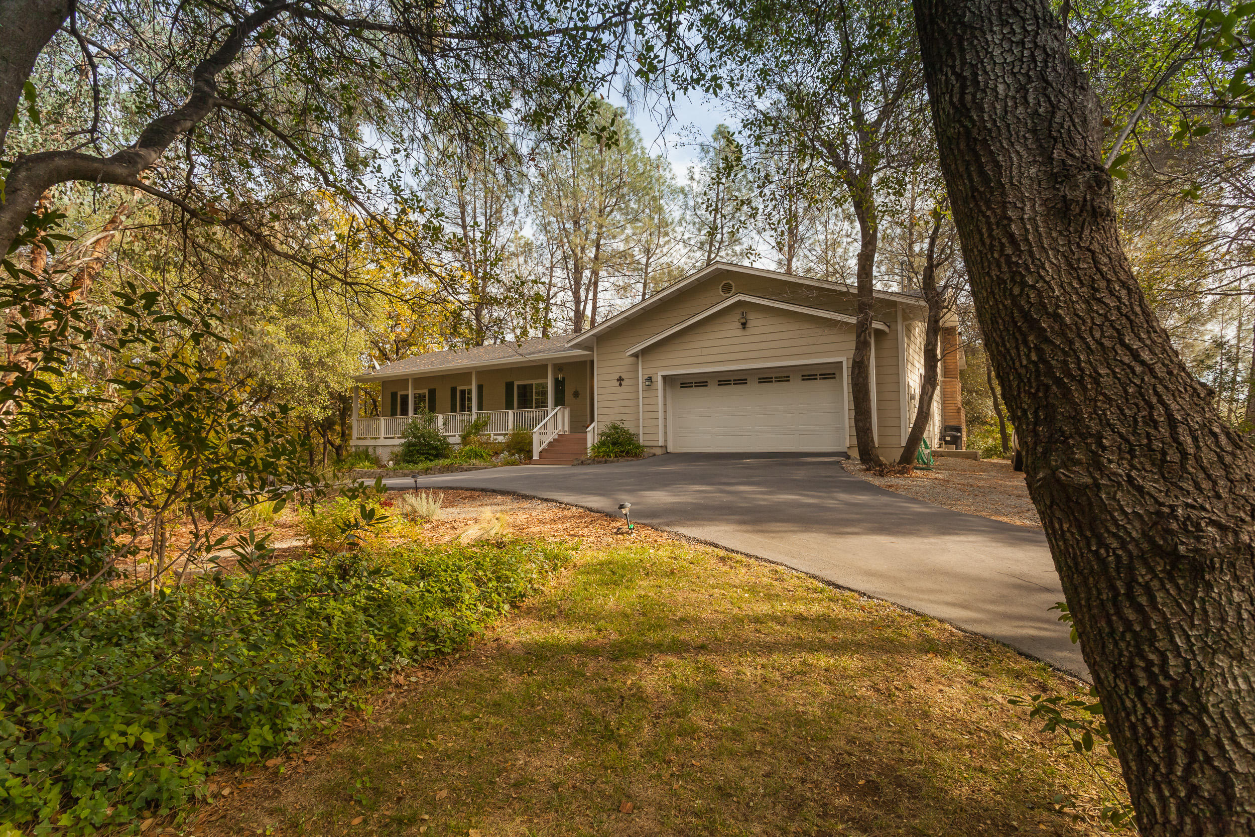 12199 Macs Road Redding, CA 96003 - Photo 3 of 36 a front view of a house with a yard and garage
