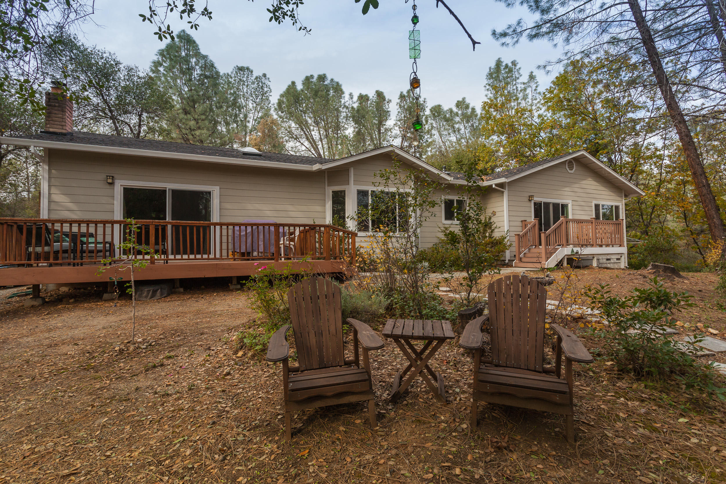 12199 Macs Road Redding, CA 96003 - Photo 32 of 36 a view of a house with a yard chairs and wooden fence