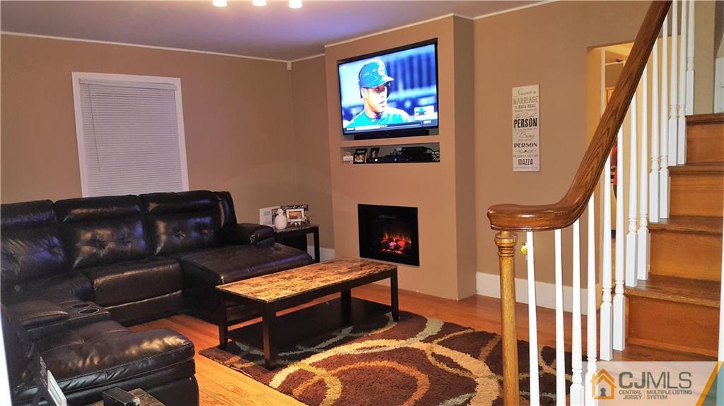 80 Jordan Road Colonia, NJ 07067 - Photo 2 of 21 a living room with furniture a fireplace and a flat screen tv