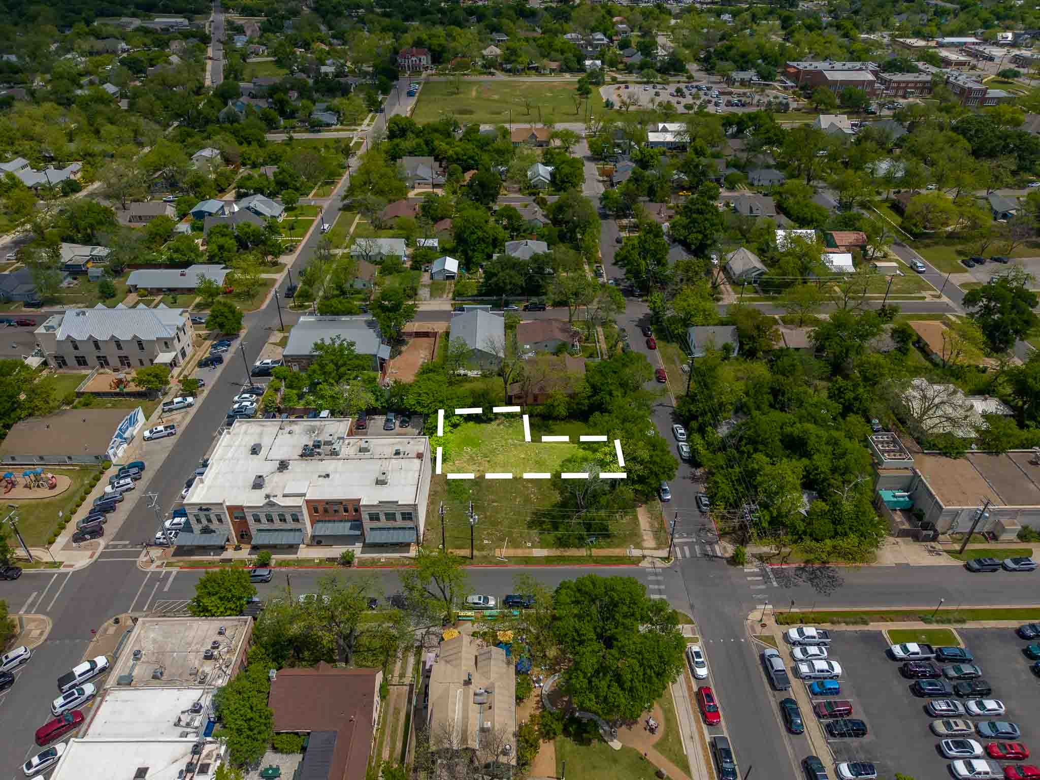 203 East 9th Street Georgetown, TX 78626 - Photo 2 of 4 Aerial perspective of a corner lot outlined in white, featuring an open, grassy expanse